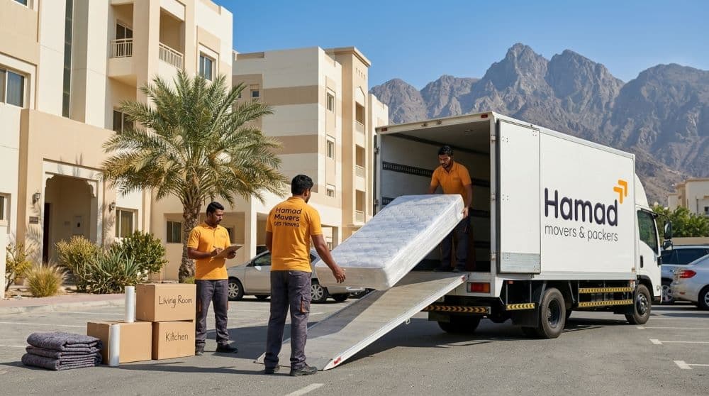 Professional movers and packers in Fujairah — Hamad Movers & Packers team loading belongings with the Hajar Mountains in the background, UAE East Coast relocation service